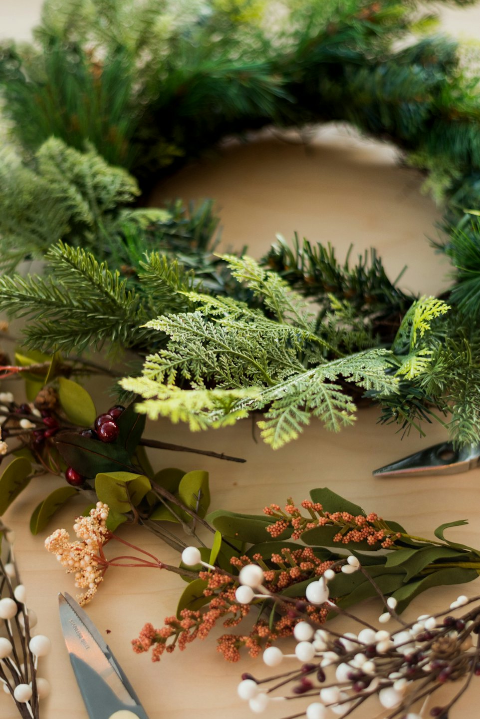 Wreath crafting supplies on a wooden table.